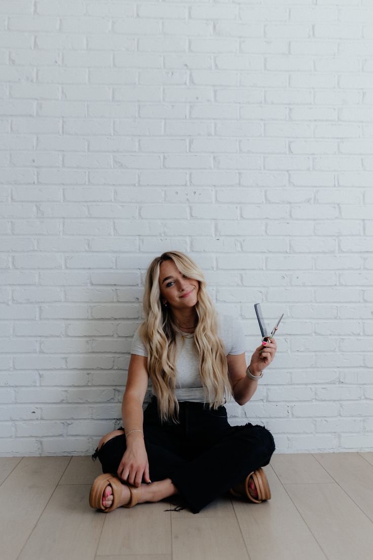 a woman sitting on the floor with scissors in her hands