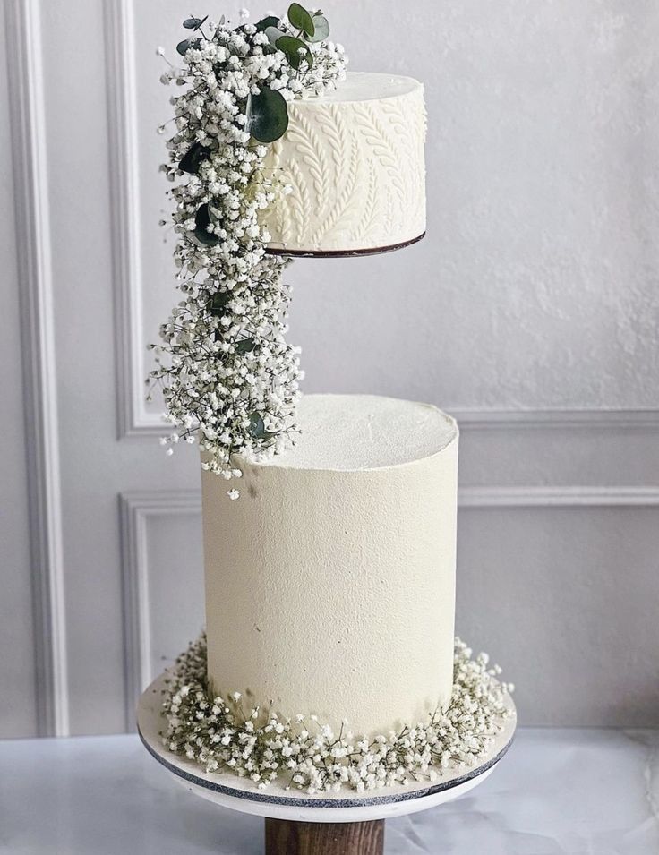 two tiered cake with white frosting and baby's breath flowers on top