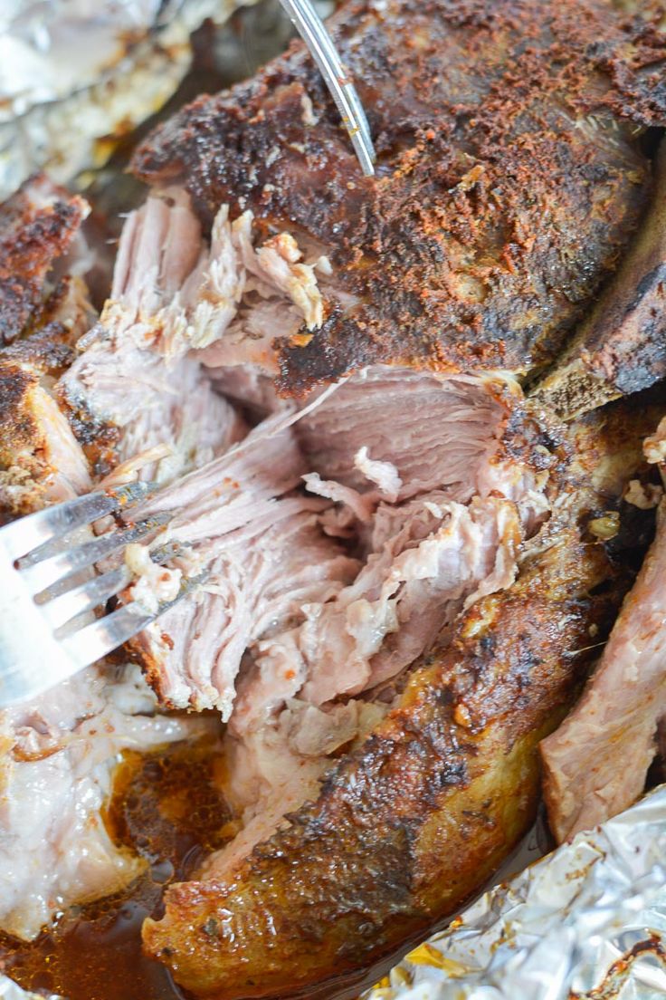 roasting meat in foil with fork and knife on it, ready to be eaten