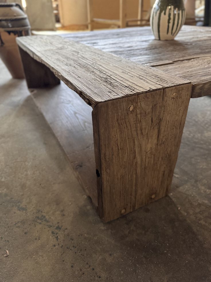 a wooden table sitting on top of a cement floor