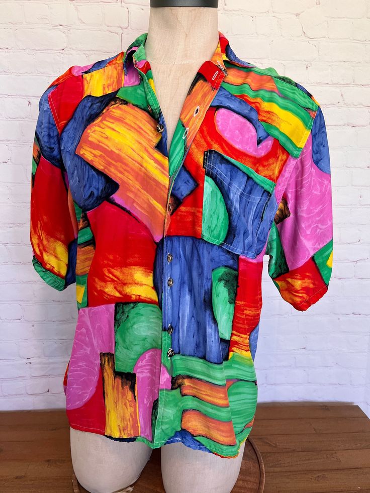 "Retro 90s Citron Santa Monica oversized shirt This gender neutral short sleeve shirt is an abstract vibrant print, One front pocket 100% Rayon Excellent condition Tag size Small Measurements when laying flat across; Chest/Bust - 22.5\" Length - 26.5\" Length on back, from shoulder seam down - 33.5\" Everything we sell is vintage, and most has been washed and worn more than once. Minor signs of wear are to be expected. Please see item details for condition notes. We make every effort to disclose as much detail as possible. Sizes are an estimate; please see full measurements to make your own assessment. Vintage sizes often run small and irregular, so tag sizes may not be accurate.  Questions prior to purchase are encouraged." Retro 90s, Color Shorts, Oversized Shirt, Santa Monica, Front Pocket, Short Sleeve Shirt, Sleeve Shirt, Gender Neutral, Adult Outfits