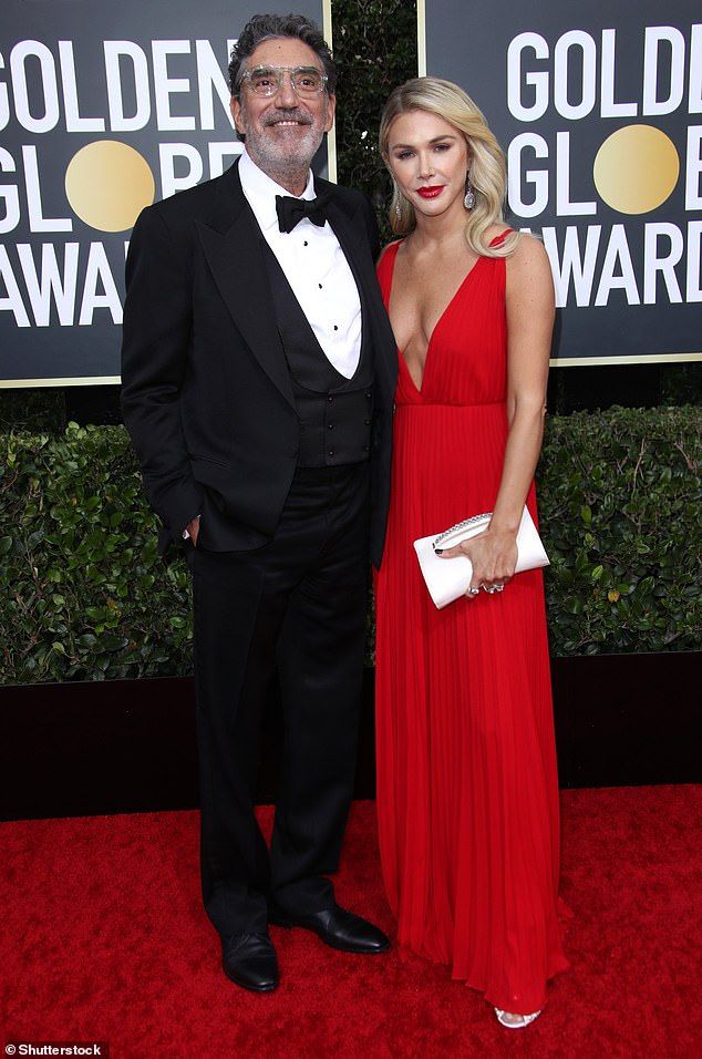 a man in a tuxedo standing next to a woman in a red dress