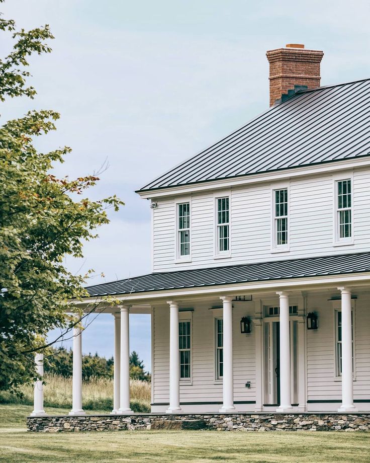 a white house with columns and a black roof