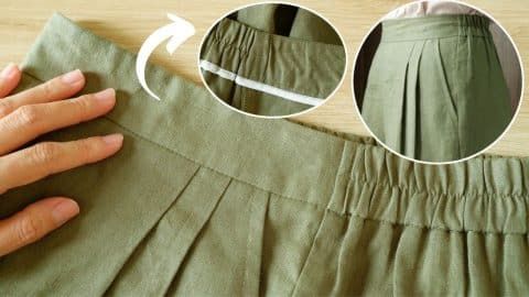 someone is sewing the bottom part of a green skirt with white piping on it