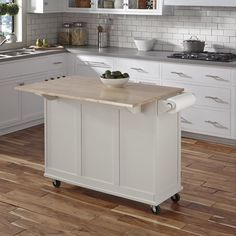 a white kitchen island sitting on top of a hard wood floor