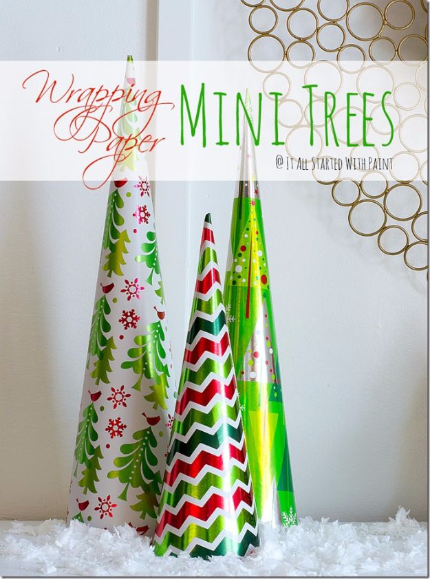 three small christmas trees sitting on top of snow covered ground with text overlay that reads wrapping paper mini trees