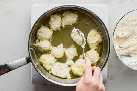 someone is cooking dumplings in a pot on the stove with a ladle next to it