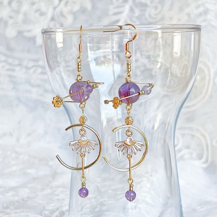 Amethyst Planet and Fan Earrings These beautiful Amethyst Planet and Fan Earrings will bring a celestial sparkle to any look. Crafted from genuine amethyst stone, the earrings feature an abstract planet design, delicately decorated with a fan-like shape for a truly unique flair. Perfect for any special occasion. As a gift shop, we offer a complimentary gift box for every order. Detail: Length of one earring - 80mm; size of beads - 5-10mm Material: ear wire - sterling silver; beads - natural Amethyst;  Note: the Amethyst Planet and Fan Earrings are handmade locally in the UK, each pieces would vary slightly in detail.  About postage: Standard postage When choosing standard postage, we assume this order is for yourself, or you will wrap the item yourself before giving it out as a gift (the c Purple Amethyst Spiritual Earrings, Spiritual Amethyst Purple Earrings, Spiritual Purple Amethyst Earrings, Purple Adjustable Celestial Jewelry, Adjustable Purple Celestial Jewelry, Celestial Purple Dangle Earrings, Purple Celestial Dangle Earrings, Purple Round Spiritual Earrings, Purple Spiritual Drop Earrings