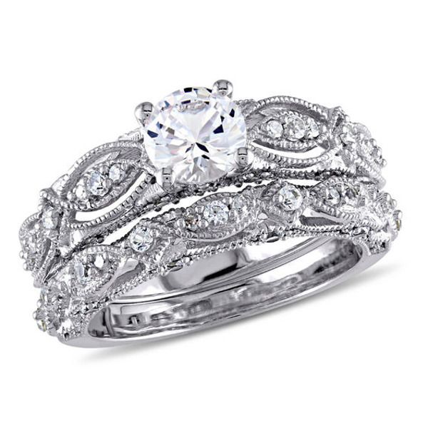 a wedding ring set with an oval cut diamond in the center and two rows of round diamonds on each band