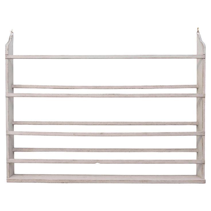 a white wooden shelf with two hooks on it