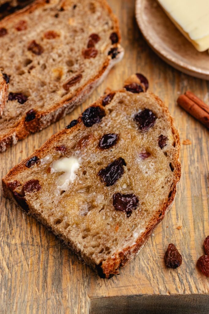 two slices of bread with raisins and butter on top