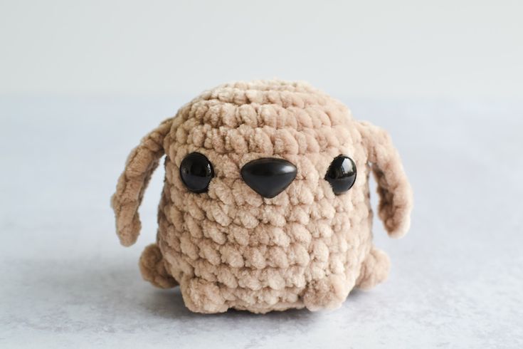 a crocheted stuffed animal with black eyes