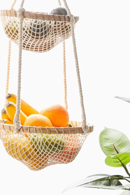 a hanging fruit basket filled with oranges and bananas