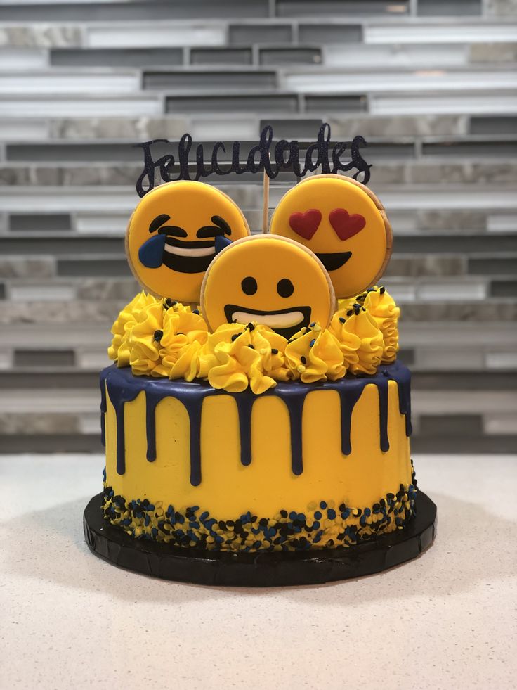 a decorated cake with yellow flowers and smiley faces