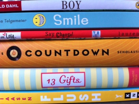 a stack of children's books sitting on top of each other in front of a window