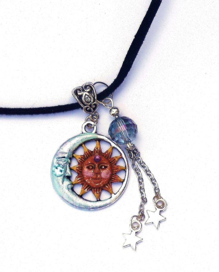 "A necklace with whimsical celestial charm featuring a silver moon and sun pendant that's been accented with violet and pinked orange! Dangling alongside,a couple of star charms swing beneath a super lustrous faceted glass bead of light turquoise! A light turquoise Swarovski crystal rhinestone sparkles from the half moons' chin & a little amethyst-colored Swarovski crystal rhinestone serves as the sun's \"third eye\" ! The artful pendant hangs from a black faux suede necklace that has an ext Whimsical Celestial, Suede Necklace, Half Moons, Moon And Sun, Sun Pendant, Large Necklace, Star Pendant Necklace, Moon Sun, Amethyst Color