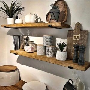 two wooden shelves filled with pots and mugs on top of each other in a kitchen