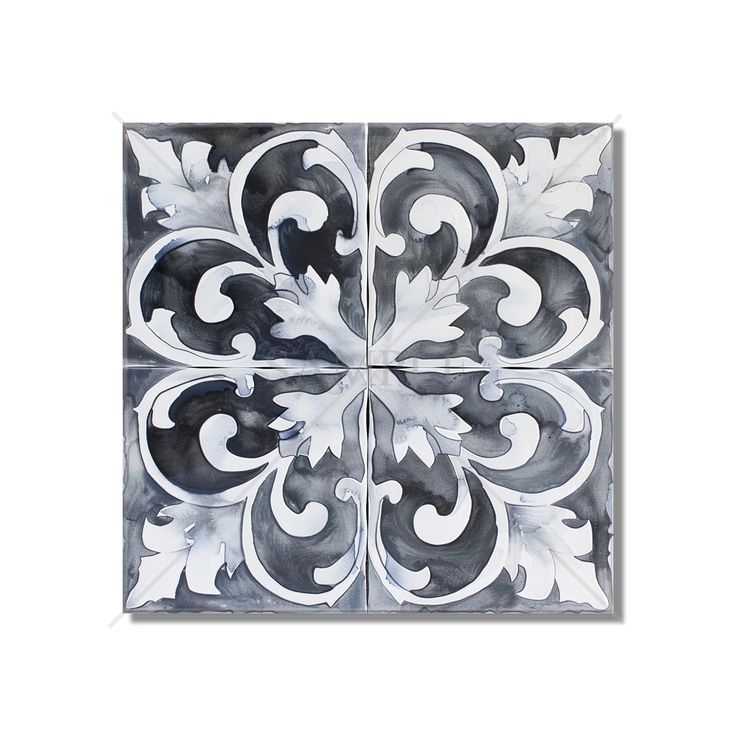 a white and black tile with an artistic design on it's center, surrounded by leaves