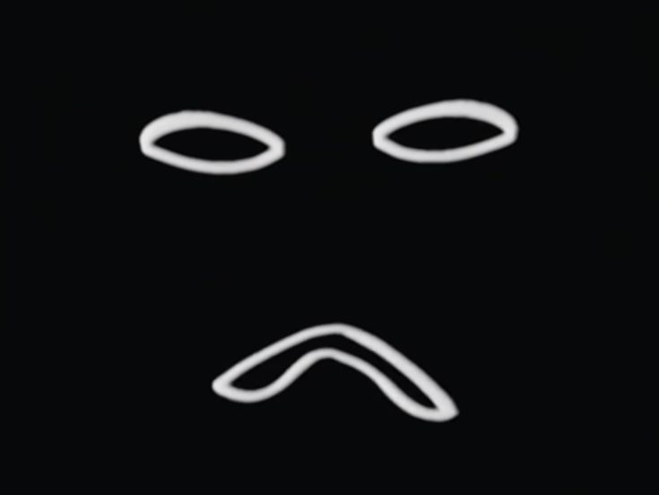 the face is drawn in white on a black background, and appears to be frowning