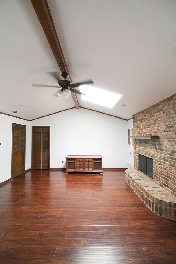 an empty room with wood floors and a ceiling fan