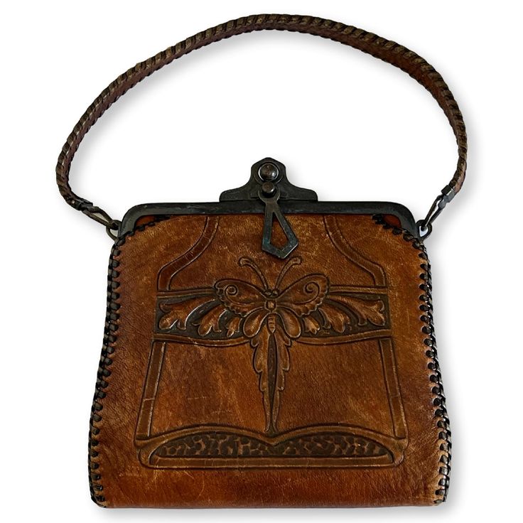 "Antique hand-tooled leather Bosca Nelson Edwardian handbag. made circa 1920s. Bosca was an Italian American immigrant whose handbags are of the highest workmanship and quality. Art Deco styling with butterfly and flowers. Clasp is in good working condition and interior is clean. Maker's tag inside. 10\" bottom to top; 6\" Wide." Vintage Embossed Satchel For Everyday Use, Vintage Embossed Satchel Bag, Vintage Embossed Shoulder Bag For Daily Use, Vintage Embossed Leather Shoulder Bag, Vintage Leather Embossed Shoulder Bag, Vintage Brown Embossed Shoulder Bag, Vintage Leather Shoulder Bag With Embossed Details, Vintage Brown Embossed Satchel, Vintage Embossed Leather Bags