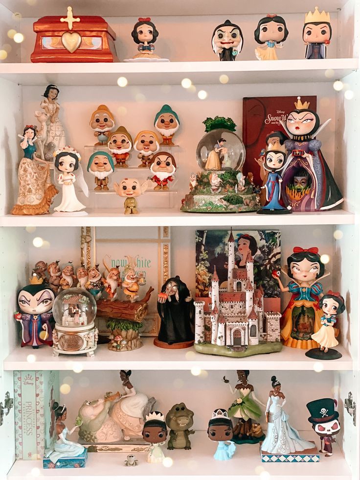 a shelf filled with lots of figurines on top of white shelves next to each other