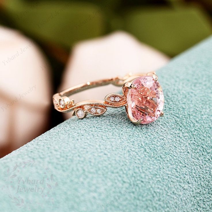 a pink diamond ring sitting on top of a blue towel