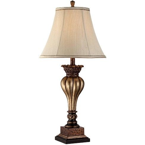 a lamp that is sitting on top of a wooden base with a white shade over it