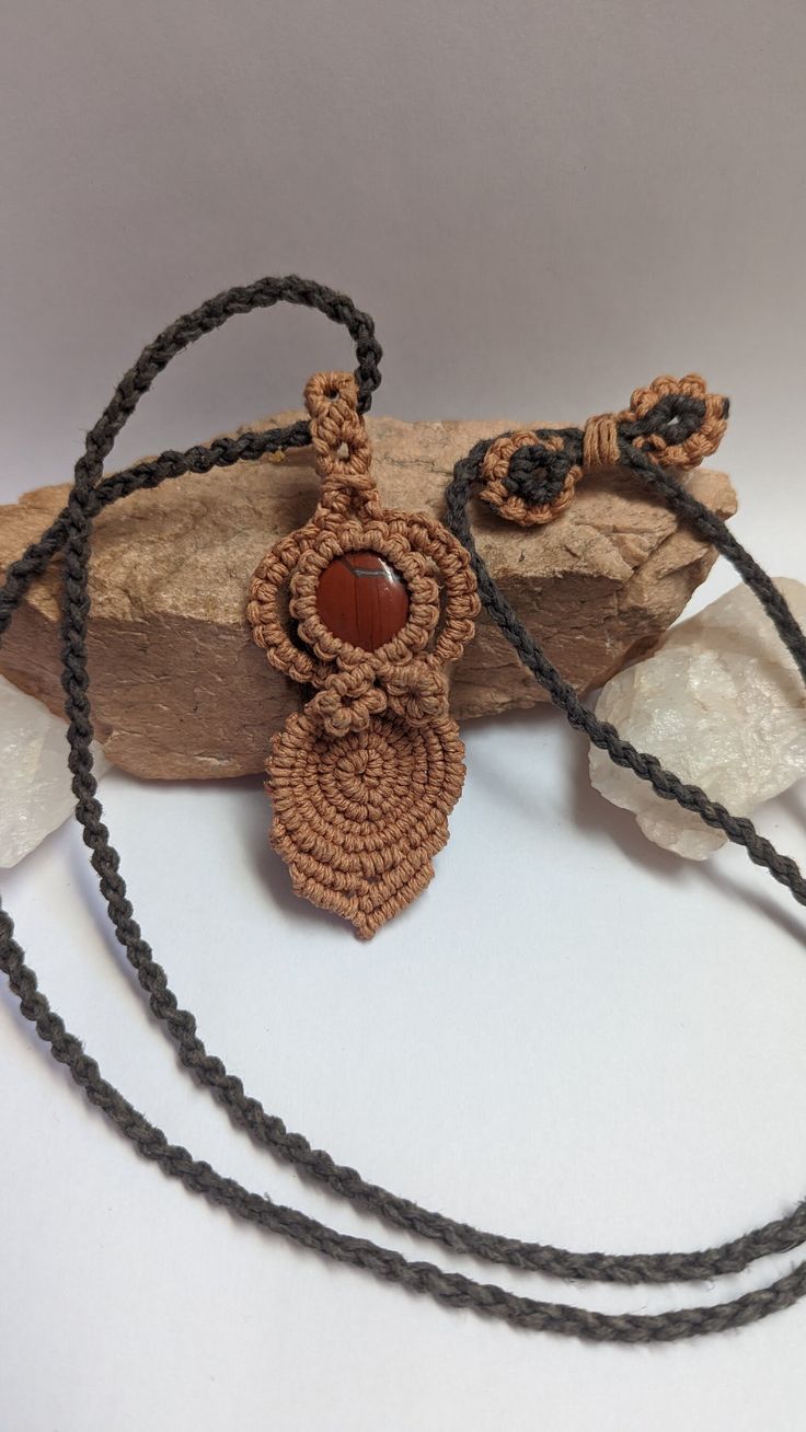 A beautiful Goddess pendant made with a Red Jasper cabochon accented with light caramel and gray hemp cord. Each order comes packed in a 100% cotton muslin bag ready for gifting! Pendant size: 3 1/2" x 1 1/4" Necklace length: 32" max, adjustable Unique Brown Macrame Necklace, Handmade Brown Cord Jewelry, Adjustable Orange Macrame Jewelry, Orange Macrame Jewelry As Gift, Brown Macrame Nature-inspired Jewelry, Nature-inspired Brown Macrame Necklaces, Earthy Brown Macrame Jewelry, Nature-inspired Brown Macrame Jewelry, Goddess Pendant