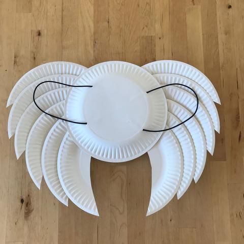 paper plate angel wings on a wooden floor