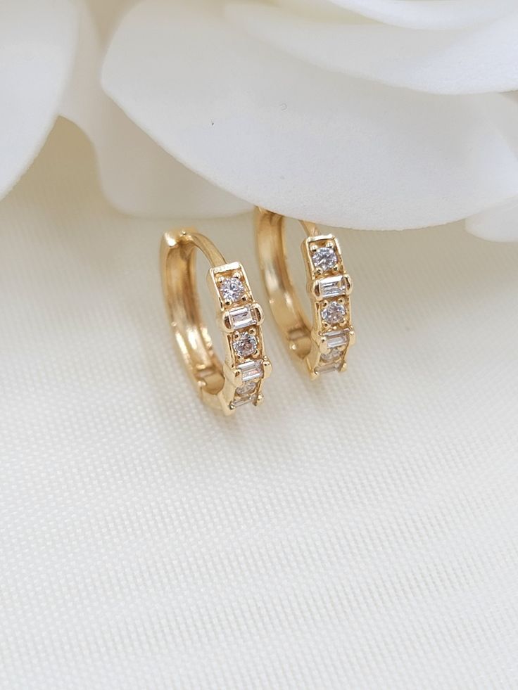 Beautiful solid 14k yellow gold Bagguete and round CZ Huggies Earrings. Perfect for everyday and every occasion. Modern, unique and versatile. Will match any outfit. 14k gold will not tarnish or rust. Materials: 14k gold, cubic zirconia diamonds Diameter: 12.5mm Width: 3mm Weight: 1.5 Grams 14k gold stamped Fast shipping Follow us for more fine 14k Gold jewelry Contact me with all your questions i will be happy to help Classic Gold Diamond Earrings With Baguettes, Classic Gold Diamond Earrings With Baguette Diamonds, Gold Baguette Cut Diamond Earrings, Classic Gold Baguette Diamond Earrings, Gold Baguette Diamond Earrings For Anniversary, Anniversary Gold Baguette Diamond Earrings, Classic Gold Baguette Cut Diamond Earrings, Dainty Gold Huggie Earrings For Anniversary, Classic Gold Earrings With Baguette Diamonds