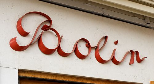 a sign that says rooiin on the side of a building with red letters