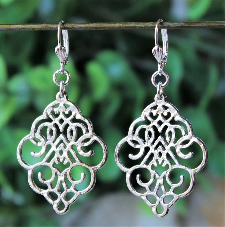 This striking pair of earrings features a beautifully detailed sculpted and hammered metal drop, made of zinc and plated in sterling silver. Hanging from a surgical steel lever-back, it measures 2 " in length. Earrings are light weight and sway gracefully as you move about your day. These stunning dangle earrings are unique, feminine and eye-catching, a great accent to any wardrobe. Available with sculpted clip-on earrings top, please see last photo. Metal Drop, Filigree Earrings, Earrings Metal, Hammered Metal, Earrings Hoop, Silver Dangle Earrings, Big Earrings, Earrings Statement, Pretty Gift