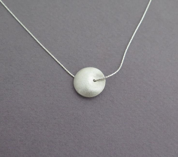 Delicate silver necklace for yourself or as a gift, with a unique bead. Both sides of the bead look the same, it's diameter is about 1.6 cm - 0.6 inch, with a grainy textured matte finish. The chain is 40 cm/16 inch long. Please contact me if you like to have a longer chain. I also have this necklace in 14k gold, with a smaller bead, here: https://www.etsy.com/listing/74255864 For another version of this necklace, click here: https://www.etsy.com/listing/79578221 To get back to my shop, click he Silver Ball Chain Necklace As A Gift, Silver Necklace With Ball Chain As Gift, Silver Necklace With Ball Chain For Gift, Minimalist Round Bead Necklaces For Gifts, Minimalist Round Bead Charm Necklace As Gift, Sterling Silver Charm Necklaces With Round Beads, Circular Silver Chain Necklace Gift, Gift Sterling Silver Necklace With Spacer Beads, Gift Silver Chain Necklace