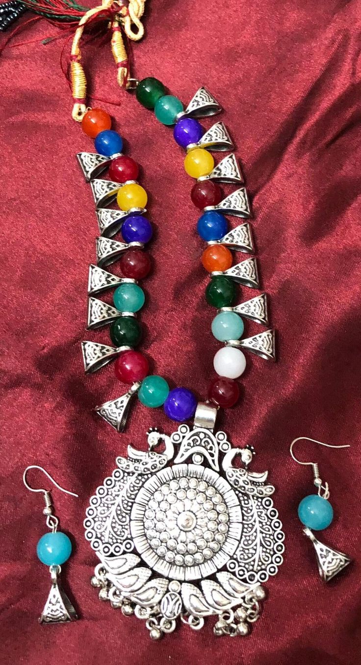 This style of Choker and Earrings set is a traditional and iconic style of jewelry that originated from India and is popular throughout the Indian subcontinent. This set is known for it's distinctive design. This type of jewelry is a significant part of Indian culture and is worn by women on various occasions, including weddings, festivals, and other celebrations. The choker necklace has a detailed design in the pendant and colorful beads in necklace make this a beatiful set to treasure.  Versatility: This set commonly worn with traditional Indian attire such as sarees and lehengas, they can also be paired with contemporary outfits to add a touch of elegance and ethnicity to one's look. Size: Adjustable necklace Color & Design:  Multi color Note: earrings are for pierced ears only, the nec Temple Jewelry Sets With Matching Earrings, Festive Costume Jewelry Metal Earrings, Vintage Metal Jewelry With Polished Beads, Vintage Polished Metal Bead Jewelry, Festive Metal Costume Jewelry Earrings, Festive Metal Costume Earrings, Traditional Jewelry Sets With Matching Pendant Earrings, Jewelry Sets With Matching Round Bead Earrings, Multicolor Temple Jewelry Pendant Set