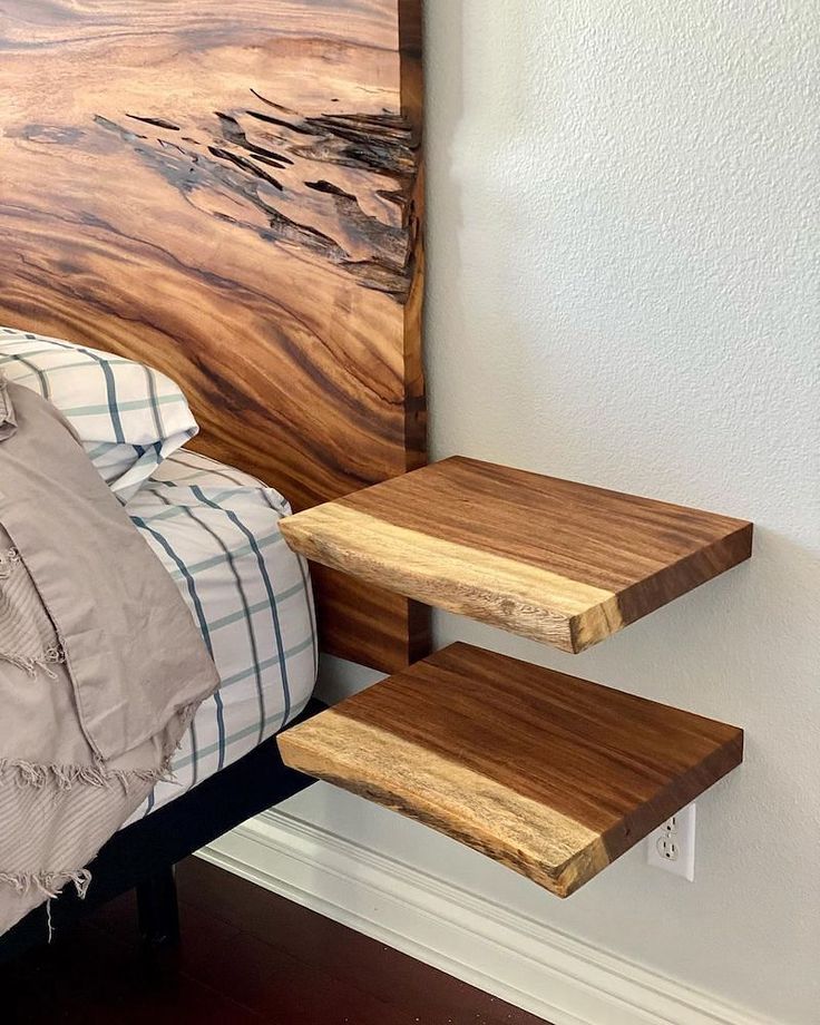 a bed with a wooden headboard and two shelves on the wall next to it