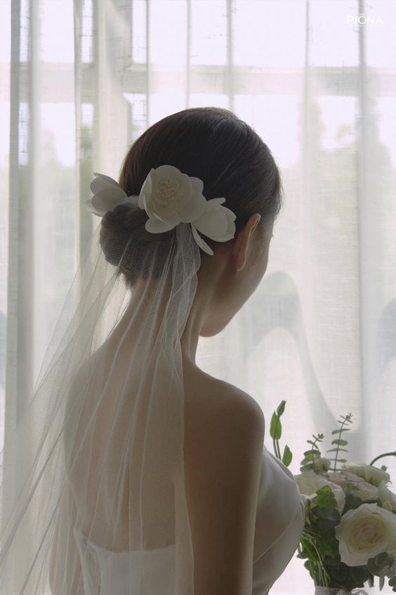 a woman wearing a veil and flowers in her hair