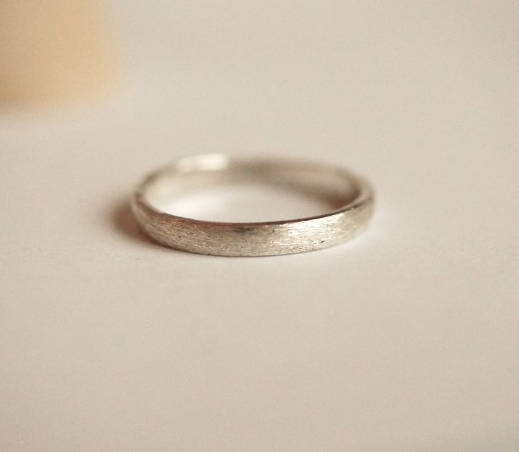 Brushed silver half domed sterling silver ring band.  Thicker profile measures 2.6mm wide and 1.25 thick with a brushed distressed finish. Hand forged and textured in my tiny studio located in historic fort Langley. Shipping within Canada is by Canada post letter mail and is untracked.  track provided with upgraded shipping purchased on checkout. Us shipping is USPS first class and included tracking. Polished Rounded Promise Ring Jewelry, Simple Hammered Ring Jewelry, Wedding Jewelry With Polished Rounded Finish, Minimalist Jewelry With Polished Finish And Rounded Edges, Minimalist Jewelry With Polished Rounded Edges, Polished Finish Wedding Jewelry, Anniversary White Gold Ring With Rounded Shape, Classic Rings With Brushed Finish As Gift, Classic Ring With Brushed Finish As A Gift