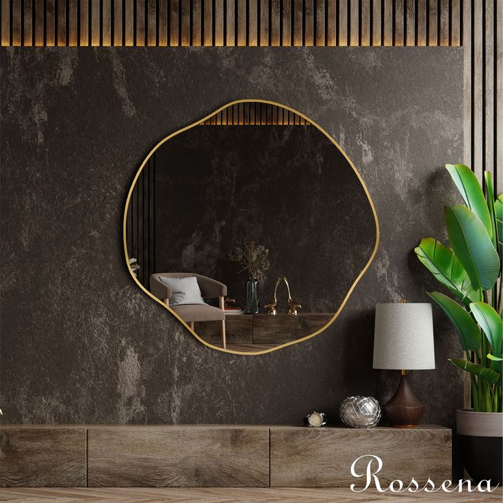 a round mirror on the wall above a table with a lamp and potted plant