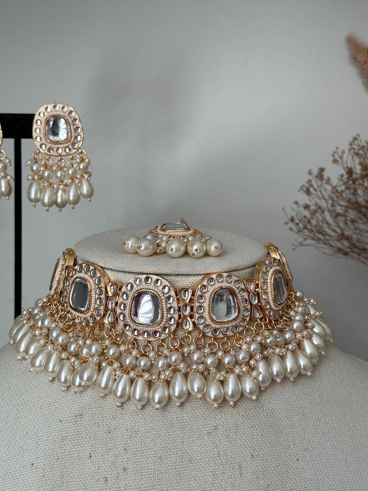 This stunning  uncut kundan necklace set comes with earrings tikkq . It's sleek and Lightweight . Great for modern and traditional look. Goes with traditional Indian dress , saree or western dress.    Choker width- 1.5 inches  Earrings- 2 inches  Style tip- ----------- Pair it with any beautiful traditional outfits  and flaunt with Unique style of collection from us. Perfect match for Festival and Traditional wear.  Take Care Tips-  ---------------- Kee away from perfume, Hair spray and. Moistur Luxury Kundan Temple Jewelry Earrings, Luxury Silver Kundan Necklace For Wedding, Affordable White Elegant Kundan Necklace, Luxury Silver Kundan Wedding And Engagement Jewelry, Luxury Traditional Bridal Necklace With Latkans, Costume Jewellery Indian, Luxury Kundan Jewelry Sets With Latkans, Luxury Heavy Kundan Necklace For Eid, Bridal Kundan Jewellery Set Kameswari Jewellers