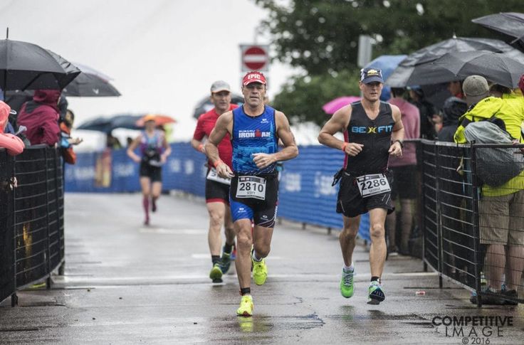 people running in the rain with umbrellas over their heads and onlookers watching