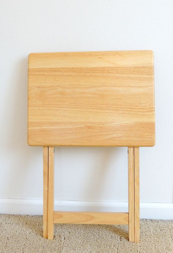 a wooden table sitting on top of a carpeted floor next to a white wall