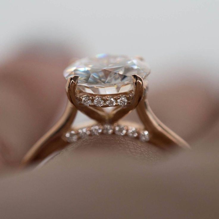 a close up view of a diamond ring on someone's finger, with the center stone surrounded by diamonds