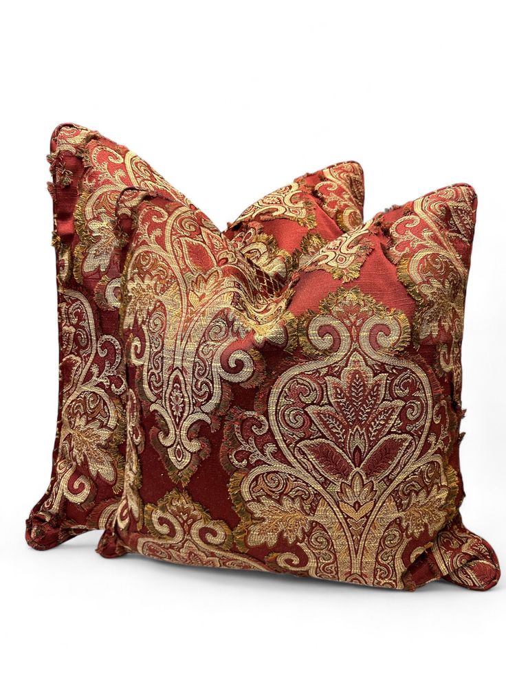 two red and gold pillows on white background