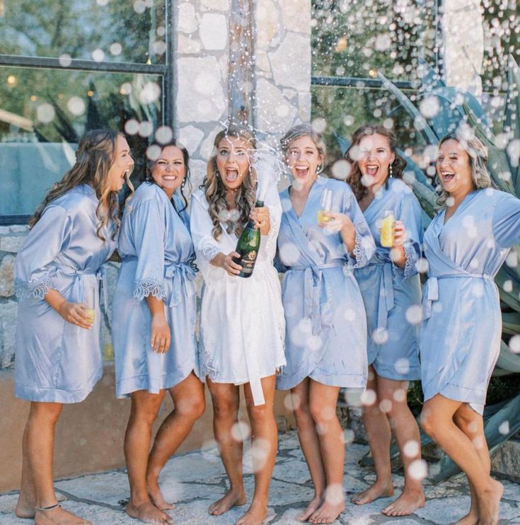 a group of women standing next to each other in front of a building with bubbles