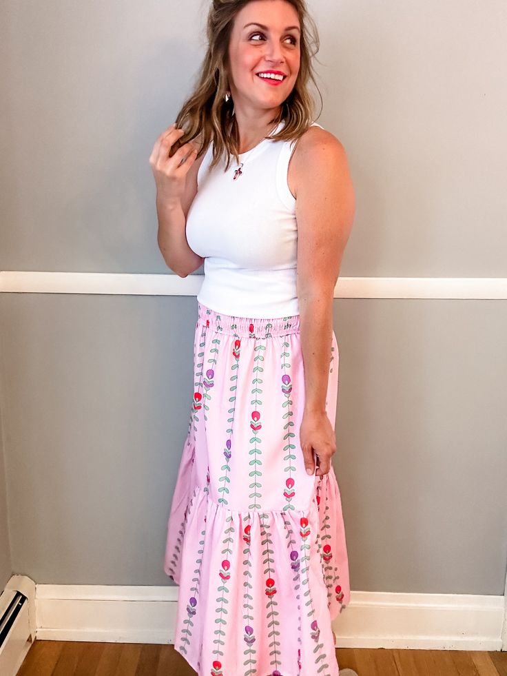 Transform your summer wardrobe with our Pink Tulip Tiered Skirt. This playful and fun piece features a stunning pattern and beautiful colors, perfect for bringing a pop of color to any outfit. With a smocked waist and lining, it not only looks great but also offers a comfortable fit. A must-have for any fashion-forward individual looking to make a statement! Fit is true to size. Emily is 5'8" wearing a medium. Small (0-4) Medium (6-8) Large (10-12) XL (14-16) Spring Vacation Gathered Maxi Skirt, Spring Vacation Maxi Skirt With Gathered Detail, Summer Flared Maxi Skirt With Elastic Waistband, Spring Skirt With Smocked Bodice, Summer Style Gathered Maxi Skirt, Feminine Bottoms With Smocked Bodice For Summer, Feminine Summer Bottoms With Smocked Bodice, Feminine Maxi Skirt For Summer Vacation, Pink Skirt With Smocked Bodice For Summer