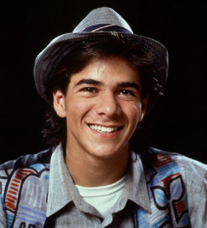 a young man wearing a hat and smiling