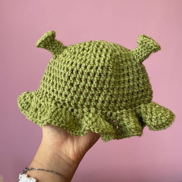 By VERY popular demand, I introduce to you the cutest little Shrek hat you've EVER SEEN! Handmade crochet Shrek hat for babies aged from 0-6 months ish, or a little older as there's plenty of stretch in the material. Made using super soft acrylic yarn which is gentle on your baby's skin, and can be washed on a low heat with your usual washing. Can be made in any 3 of the Shrek-ky green shades, perfect gift for Shrek loving parents! Cute Beanie Hat One Size Fits Most, Cute Beanie Hat, One Size Fits Most, Cute One-size Knitted Bonnet, Cute Crochet Mini Beanie Hat, Cute Crochet Beanie Mini Hat, Cute Knitted Fitted Hat, Handmade Fitted Green Crochet Hat, Green Handmade Fitted Crochet Hat, Cute Yarn Beanie One Size