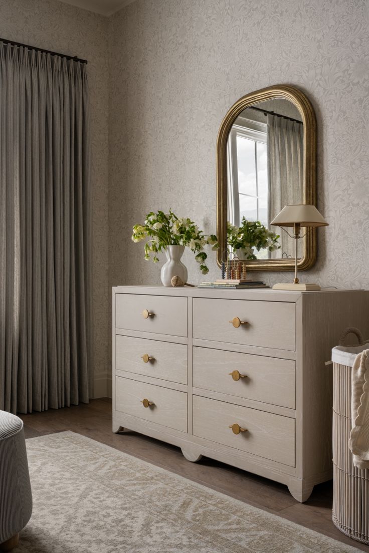 a white dresser sitting in front of a window with a mirror on top of it