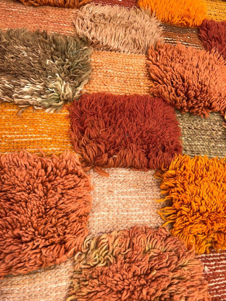 an orange and brown rug with many different colors